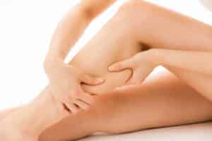 Close up of woman's legs as she holds them due to leg swelling in Walnut Creek, CA