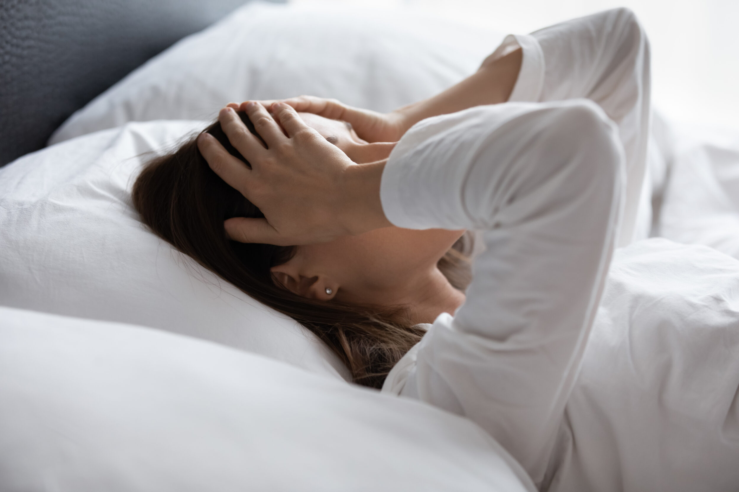 Person in bed unable to sleep due to restless leg syndrome in Walnut Creek, CA Woman having difficulty sleeping due to restless legs in Walnut Creek, CA